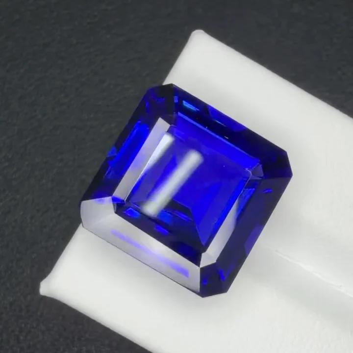 22.75 ct royal blue tanzanite, Asscher cut, on a white card