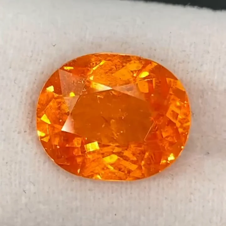 6.39 ct Fanta orange spessartite garnet, cushion modified brilliant, on white foam