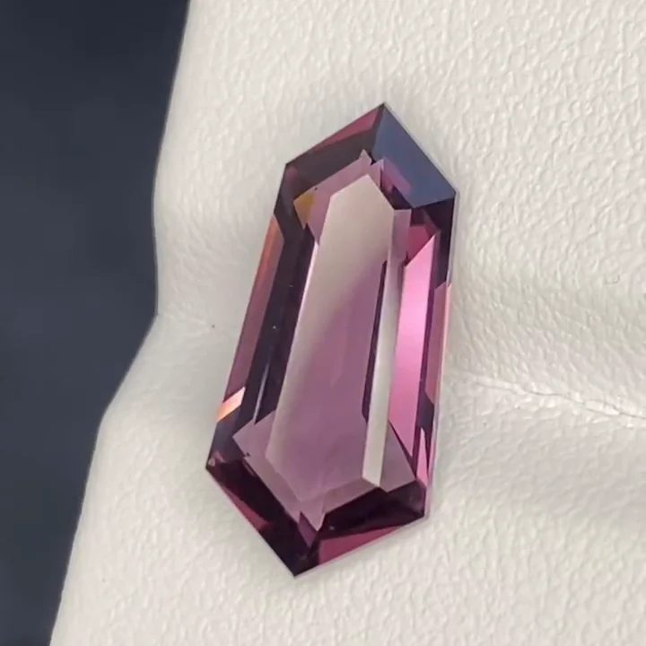 5.94 ct mauve pink spinel, fancy fantasy step cut, on a white card