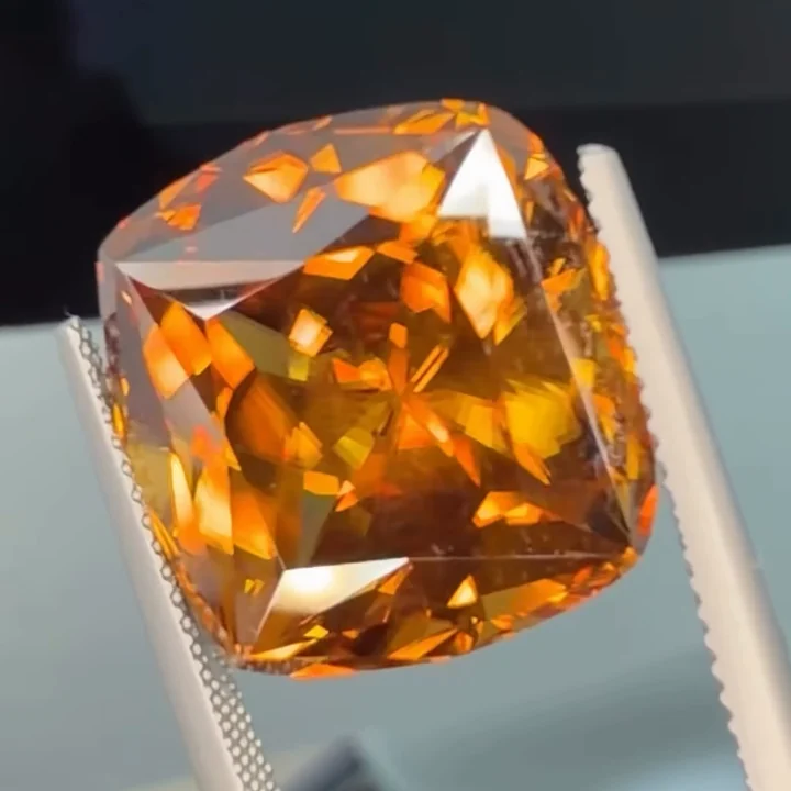 30.01 ct honey yellow zircon, fancy precision cut, held in tweezers
