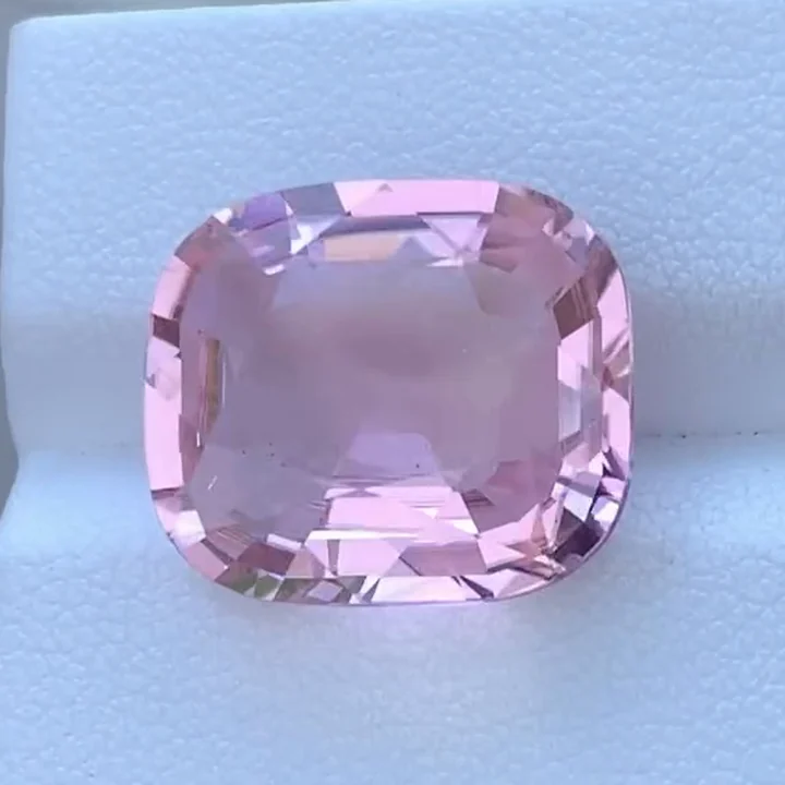12.35 ct bubblegum pink tourmaline, cushion step cut, on a white card