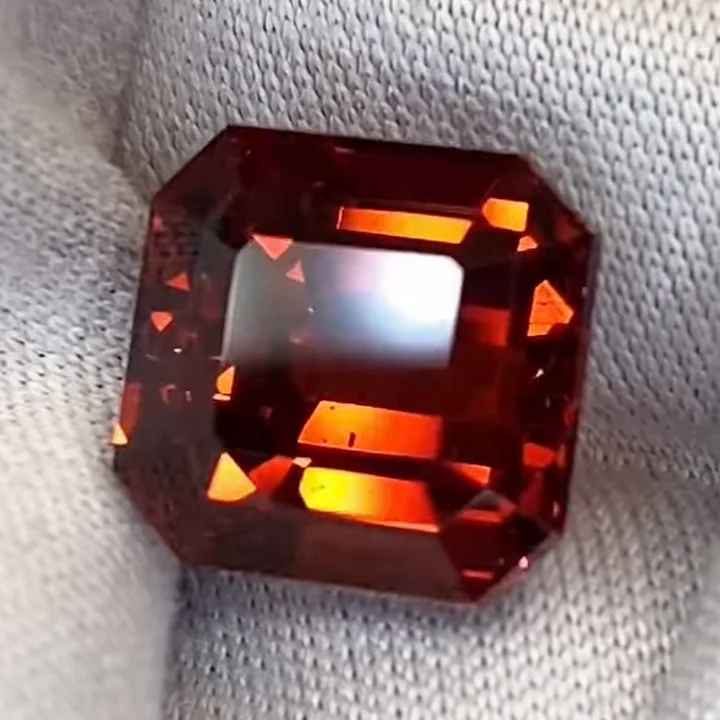 6.20 ct mandarin spessartite garnet, octagon step cut, on white cloth