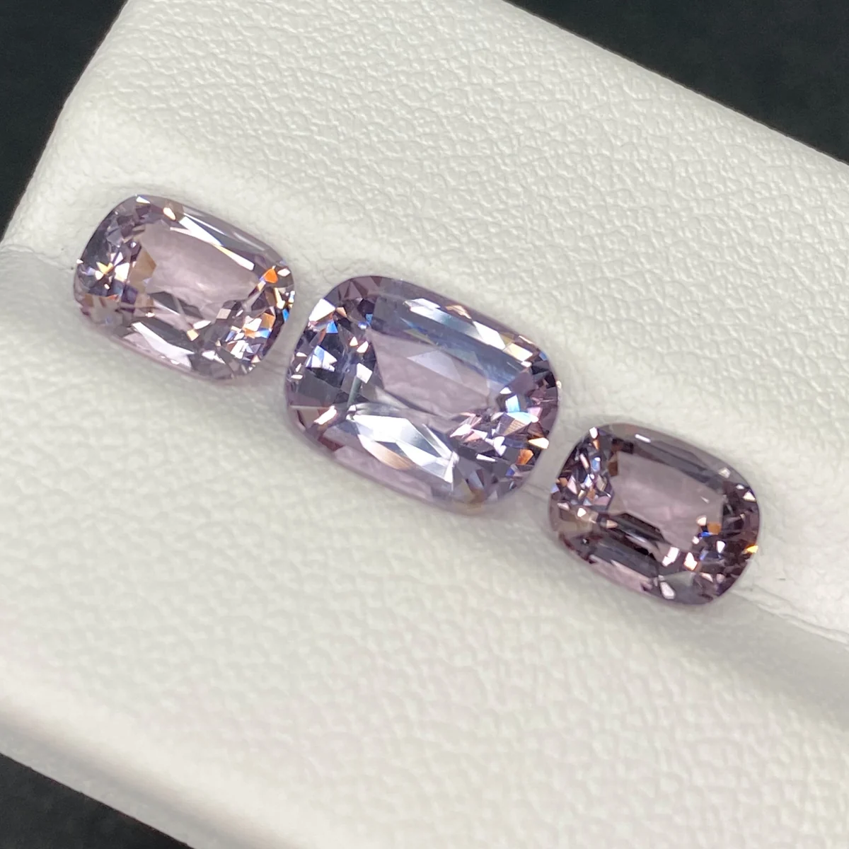 Lavender spinel trilogy, a 3.10 ct centre stone and a 2.98 ct pair, on a white tray